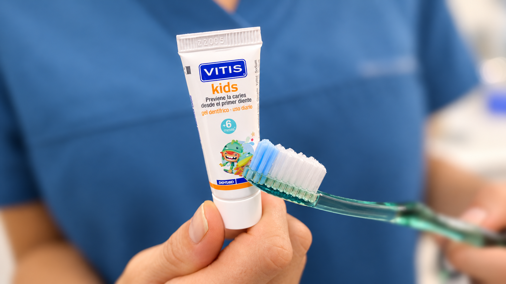 Pasta dental infantil con flúor junto a un cepillo de dientes infantil